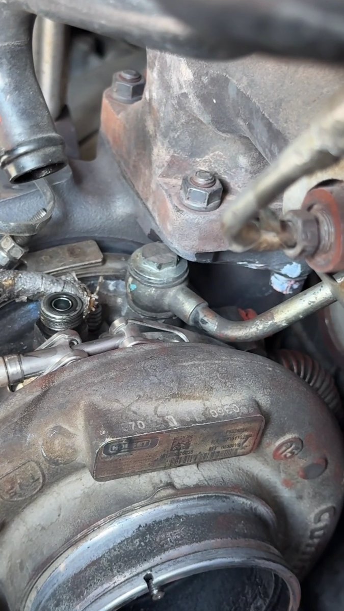Engine bay showing the botched turbo install with spliced lines